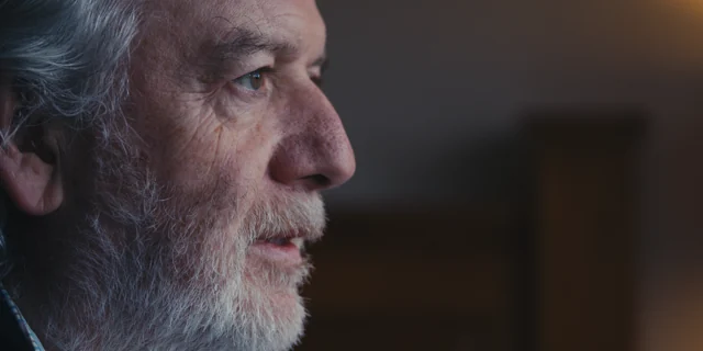 A close-up of an older man, looking towards the light.