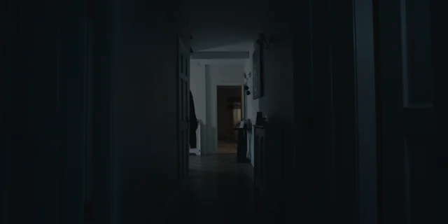 A dim hallway looks through to a room at the far end.